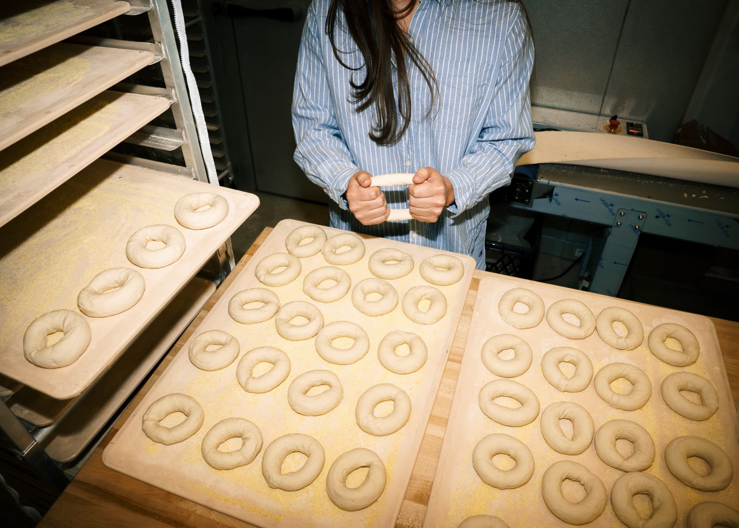 Fresh bagel dough being rolled by hand in the bakery