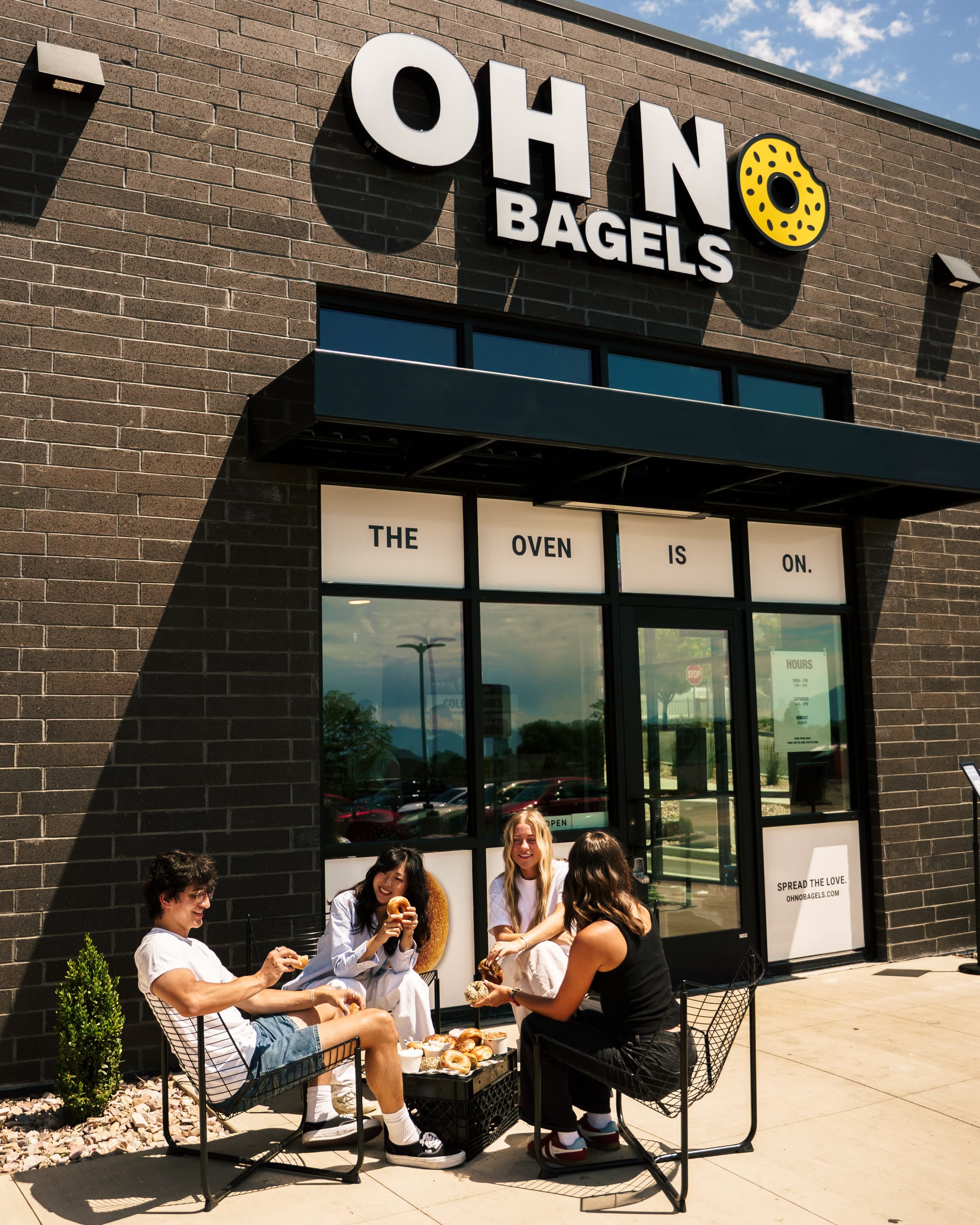 Friends eating bagels outside the Oh No Bagels shop